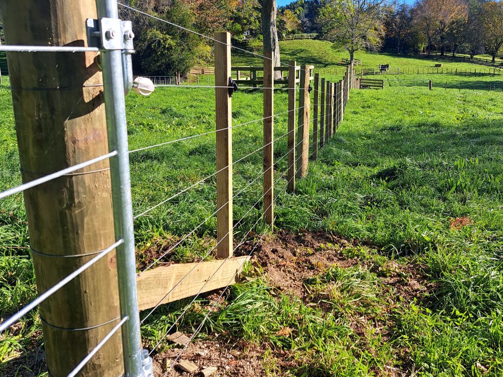 Strainer post assembly with stay and breast block on a stock fence, Rotorua